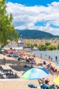 Crowds of people enjoy the summer weather on Okanagan Beach at Okanagan Lake