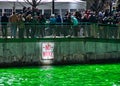 Crowds of people gather along the Chicago River, which is dyed green for St. Patrick`s day.