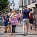 Crowds Of People Shoppers Or Customes Walking Along A Downtown High Street