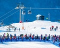 Crowds of people waiting in line by the chair lift at Hafjell alpine ski resort