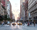 Crowds of people walk across busy New York City Street