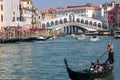Crowds of tourists and boats at the famous Rialto Bridge spanning the Grand Canal of the city of Venice