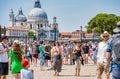 Crowds of tourists strolling on the cobblestone alley near Grand Canal in Venice