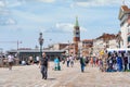 Crowds of tourists strolling on the cobblestone alley near Grand Canal in Venice