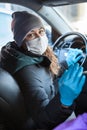 Crowdsourced taxi driver looking at the passenger wearing a facemask and latex gloves, asking to put mask on face Royalty Free Stock Photo