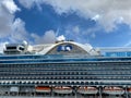 The Crown Princess cruise ship, is owned by Carnival Corporation, docked at Aruba on a sunny day with blue skies