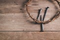 Crown of thorns with iron nails and a hammer on rustic wooden table, dramatic light and copy space, symbolizing crucifixion, Royalty Free Stock Photo