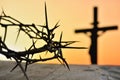 Crown of thorns of Jesus Christ against silhouette of catholic cross at sunset background Royalty Free Stock Photo