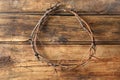 Crown of thorns on wooden background, top view. Easter attribute Royalty Free Stock Photo