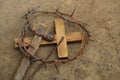 Crown of thorns, wooden cross and hammer with nail on ground, above view. Easter attributes Royalty Free Stock Photo