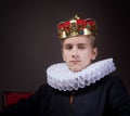 Crowned boy sitting in an armchair