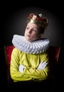 Crowned boy sitting in an armchair