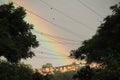 Rainbow over houses and cables energy trees Royalty Free Stock Photo