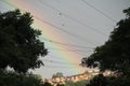 Rainbow over houses and cables energy trees Royalty Free Stock Photo