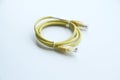 Yellow rolled-up patch cable, used to connect a computer to an internal or external network, internet connection, Royalty Free Stock Photo