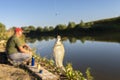 Crucian fish caught on bait by the lake, hanging on a hook on a fishing rod, in the background an angler catching fishes.