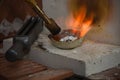 Crucible with liquid silver melted with fire at high temperatures