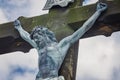 Crucified Jesus. Figure of Christ against background of blue sky. Old stone cross