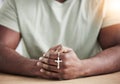 Crucifix cross, man hands and prayer beads in home with faith, christian praise and religion. Praying, necklace and Royalty Free Stock Photo
