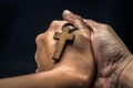 The crucifix is in the hands of a man who is praying for the blessing of his god with faith