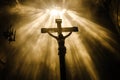 A crucifix illuminated by rays of light in a dark room, signifying divine presence Royalty Free Stock Photo