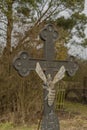 Crucifix near trees and bee house with bee on cross