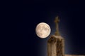 Crucifix on a tombstone in the full moonlight.