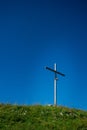 Crucifix on the top of the mountain in the middle of a meadow