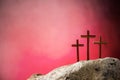 Crucifixion, resurrection of Jesus Christ. Three crosses against red sky on Calvary hill background. Christian Easter Royalty Free Stock Photo