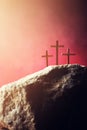 Crucifixion, resurrection of Jesus Christ. Three crosses against red sky on Calvary hill background. Christian Easter Royalty Free Stock Photo