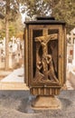 Crucifixion scene on a brass lamp in a cemetery