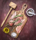 Crude appetizing chicken breast with rosemary, butter and salt on vintage cutting board hammer for meat Healthy food on woo