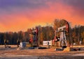 Crude oil pump jack at oilfield on atmospheric sunset backround. Fossil crude output and fuels oil production. Oil drill rig and