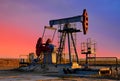 Crude oil pump jack at oilfield on atmospheric sunset backround. Fossil crude output and fuels oil production. Oil drill rig and