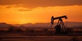 Crude oil pumpjack rig against the silhouette of the desert in the evening sunset. Royalty Free Stock Photo