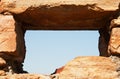 CRUDE OPENING FOR A WINDOW FRAMED WITH ROCK IN A HISTORIC FORT WALL WITH BLUE SKY VISIBLE Royalty Free Stock Photo