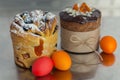 Cruffin and brown Easter cake decorated with chocolate, almond flakes and dried apricots on kitchen table among easter eggs Royalty Free Stock Photo