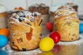 Cruffins as Easter cakes decorated with raisins, dried apricots and sugar powder on kitchen table among easter eggs Royalty Free Stock Photo