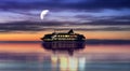 Cruise ship  in harbor at night cloudy dramatic sunset orange and lilac  sky water reflection blue sea sly and moon In harbor Royalty Free Stock Photo