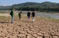 Laos: Cruise guests are walking over dry earth at the Mekong River near Luang Brabang Royalty Free Stock Photo