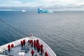 Cruise liner with passengers in front of huge Iceberg, Greenland