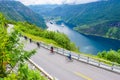 The cruise liners at the end of Geirangerfjord, near small village of Geiranger. Group of cyclists riding down Eagles Road.
