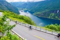 The cruise liners at the end of Geirangerfjord, near small village of Geiranger. Group of cyclists riding down Eagles Road.