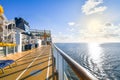 A cruise passenger uses the upper deck jogging and walking path on a luxury cruise liner with a ship in the distance on the Baltic