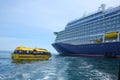 Cruise ship at anchor ourside St Peter Port, Guernsey. Large ship with blue hull and a yellow lifeboat or tenders.