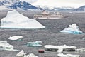 Cruise ship in Antarctia between icebergs and people in Zodiac