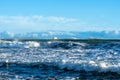 Cruise ship arriving at Mount Maunganui on horizon beyond breaking waves