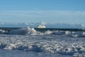 Cruise ship arriving at Mount Maunganui on horizon beyond breaking waves