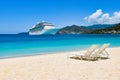 Cruise ship in Caribbean Sea with beach chairs on white sandy beach. Summer travel concept. Royalty Free Stock Photo