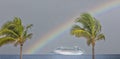 Cruise ship in Caribbean sea with rainbow and palm tree on foreground. Landscape with big cruise liner Royalty Free Stock Photo